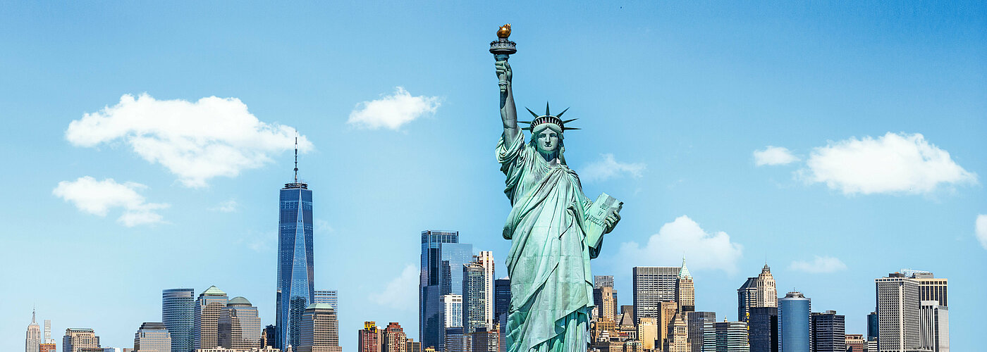 Au premier plan, la Statue de la Liberté à New York, derrière elle, Manhattan