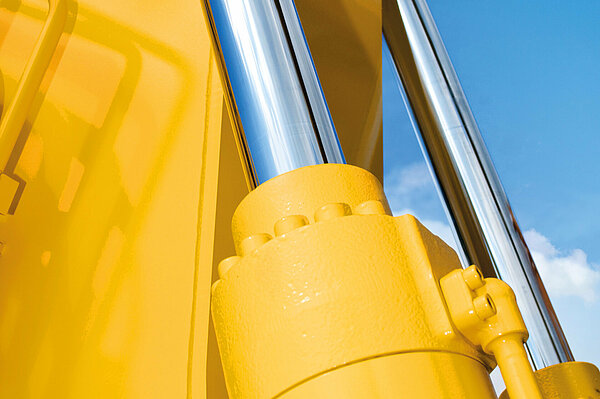 Vérin hydraulique sur machine de construction jaune