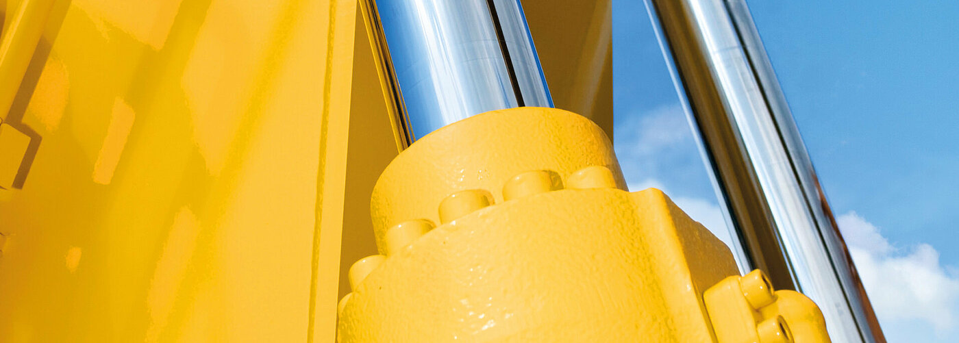 Hydraulikzylinder an gelber Baumaschine